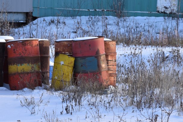 雪地里五颜六色的风化钢桶。图片下载