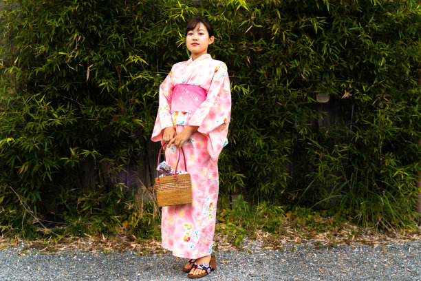 一个穿着浴巾的女人站在竹草前图片下载