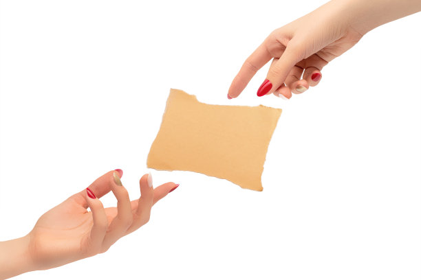 女性的手涂着红色和金色的指甲油。在白色背景上用一张孤立的纸创造人的概念。图片下载