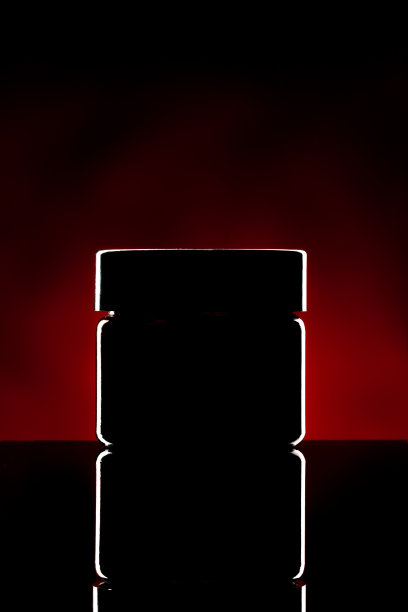 塑料罐与化妆品照亮在黑暗的背景图片下载