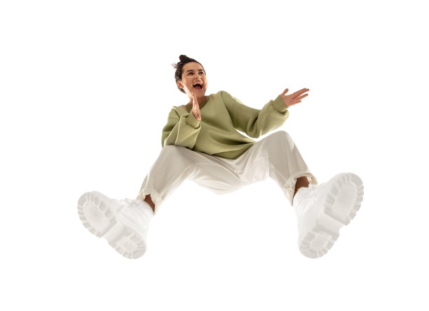 年轻时尚的女人在现代街头风格的服装孤立的白色背景，从底部拍摄图片下载