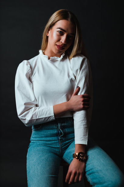 穿着白色衬衫和蓝色牛仔裤的年轻时尚女性图片下载