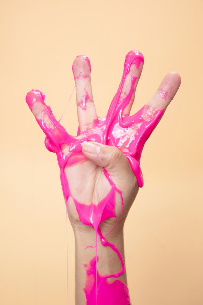 手显示第四与霓虹粉色黏液玩具在橙色波普艺术背景。图片下载