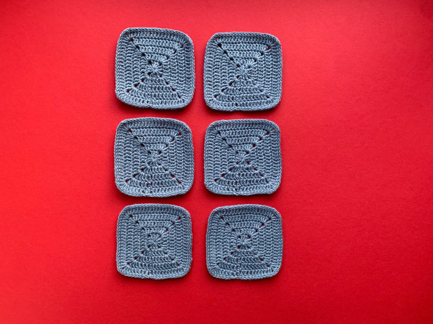 钩编。在照片中，针织元素是灰色的红色背景。从上面的照片。创造产品的概念。在黑色的背景上钩针格子。图片下载