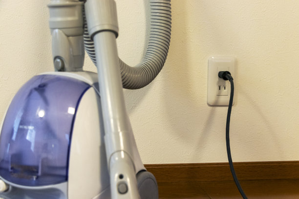 吸尘器接在墙上的电源插座上图片下载