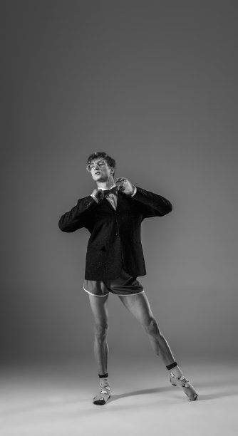 年轻、时尚、有型的男人穿着夹克和袜子在家工作。保温期间的时尚是冠状病毒大流行的原因图片下载