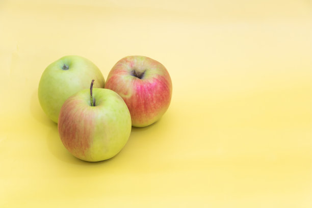 黄色背景上有几个苹果，好处是苹果的概念图片下载