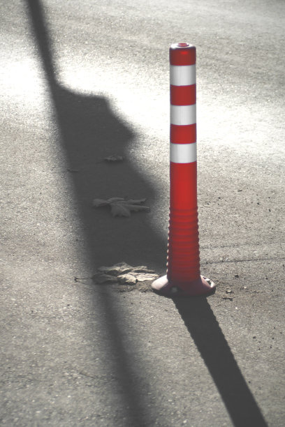 红色和白色的道路锥与强烈的阴影。图片下载
