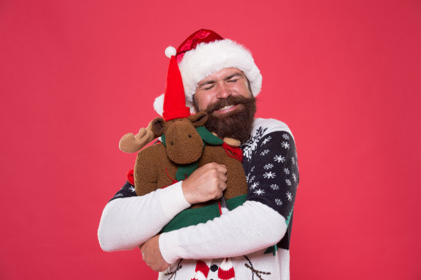 与爱。大胡子男人拥抱毛绒玩具。快乐的潮人拥抱圣诞礼物。新年拥抱。假日拥抱。幸福是一个温暖的拥抱图片下载