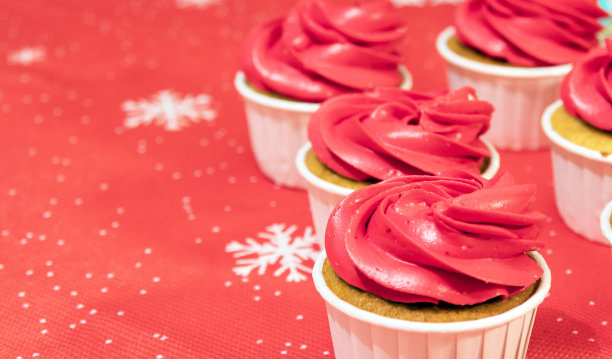 新年餐桌上的红奶油纸杯蛋糕。有选择性的重点。图片下载