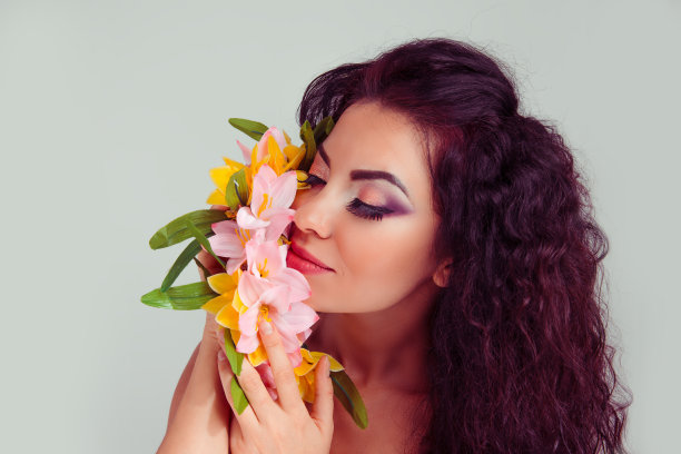 享受着香气。拿着花圈的女人闭着眼睛图片下载