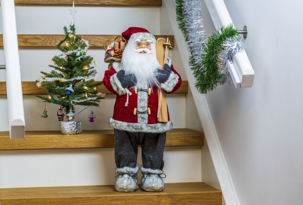 可爱的圣诞老人形象与玩具绿色的圣诞树后面。圣诞节的概念。图片下载