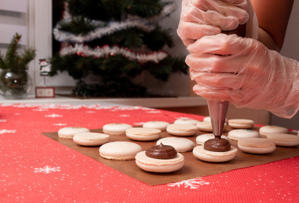 巧克力馅在马卡龙上的应用。制作圣诞甜点的过程。有选择性的重点。图片下载