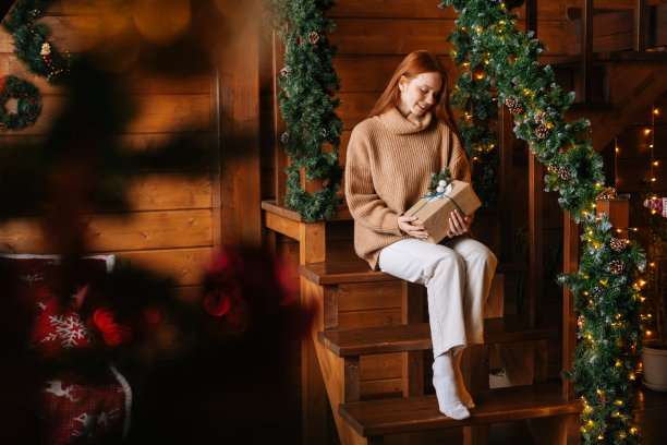 肖像迷人的年轻女子看着相机拿着礼物盒在圣诞节收到图片下载