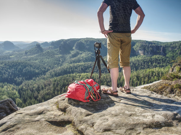 时尚的徒步旅行者停留在三脚架与相机准备拍摄风景照片图片下载