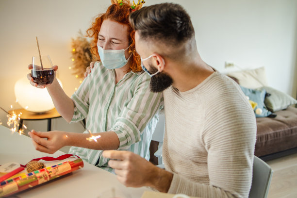 快乐的夫妇戴着面具在网上庆祝寒假的视频图片下载