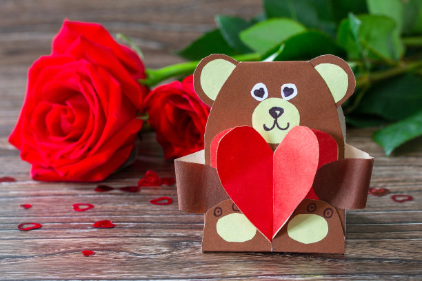 情人节的礼物——一只带心形卡片的泰迪熊。儿童创意项目，手工制作，儿童工艺品。图片下载