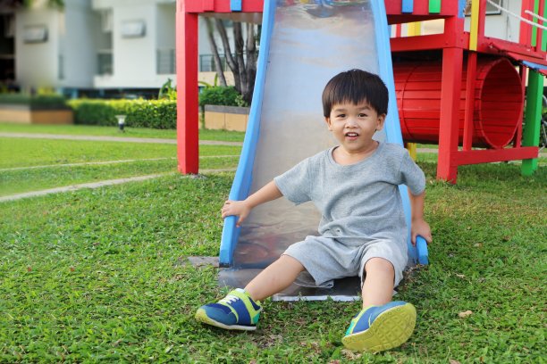 小男孩在操场上玩滑梯。图片下载