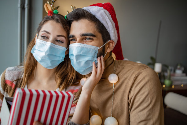 夫妇在家里戴着防护面具庆祝圣诞节图片下载