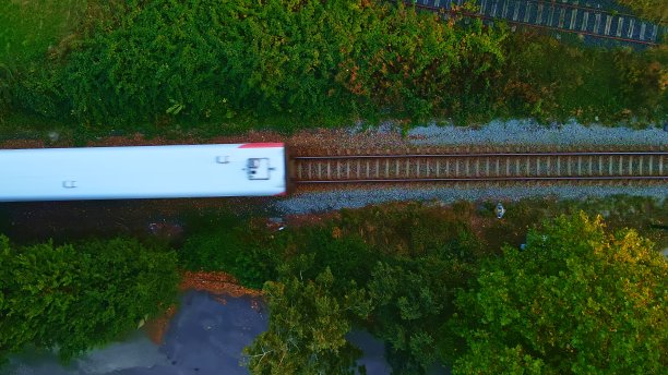 一列白人旅客列车在铁轨上驶过。鸟瞰图。图片下载