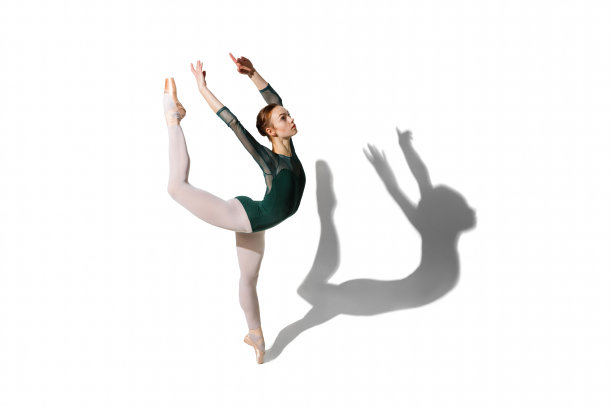 优雅的女芭蕾舞演员摆出孤立的白色背景与阴影。图片下载