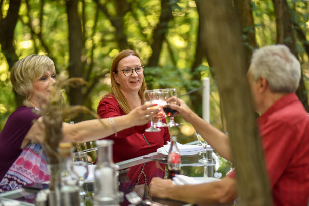 森林环境中的餐厅。快乐成熟的朋友们一起吃饭。图片下载