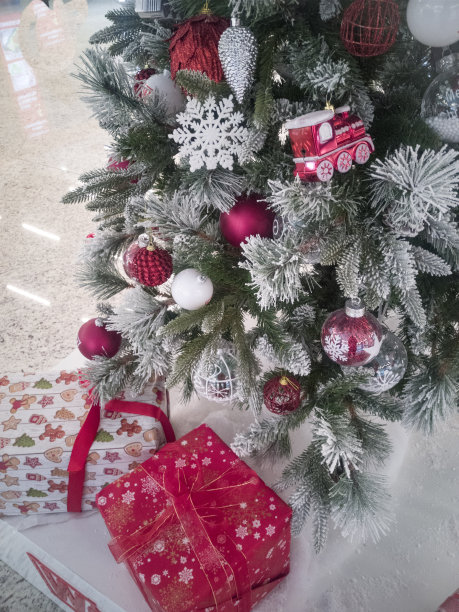 白雪覆盖的圣诞树上的红色圣诞装饰品图片下载