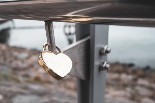 一座桥的栏杆上挂着一把心形的战前金锁图片下载