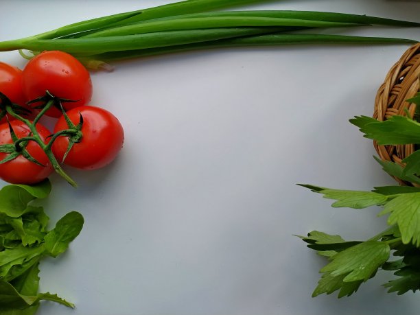 现切芹菜，西红柿，青葱。叶子沙拉在白色的桌子上图片下载