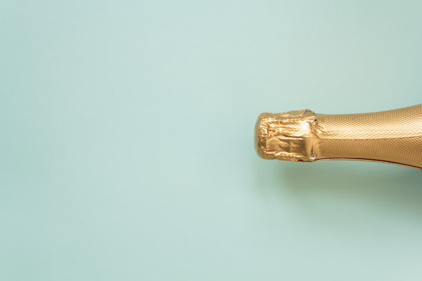 蓝色背景上的金色香槟派对瓶。俯视图，平躺与复制空间图片下载