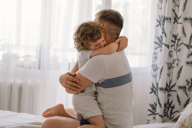 快乐幸福的家庭。爸爸和他的儿子在家里玩耍和拥抱图片下载
