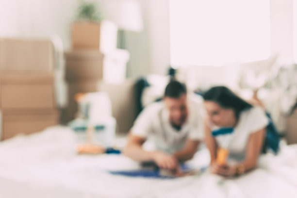 背景图片是一对年轻夫妇躺在一个空的新公寓的地板上图片下载