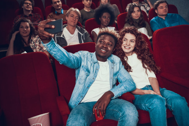 快乐的多民族夫妇用智能手机自拍。图片下载