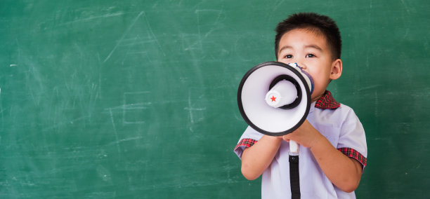 幼稚园男孩穿着学前班校服，通过扩音器说话图片下载