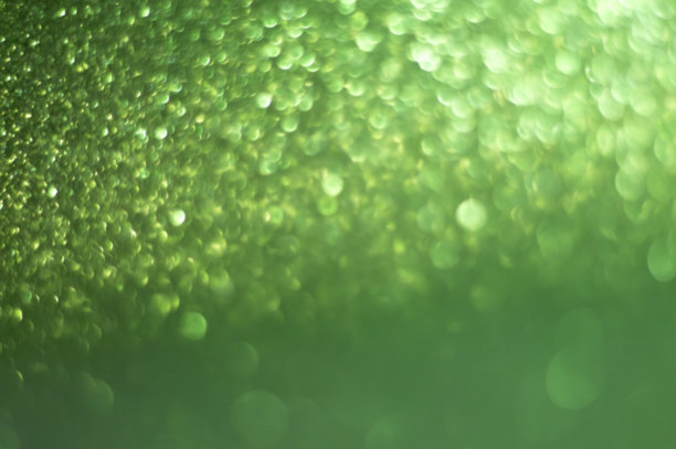 绿色模糊的背景有光泽的散景。图片下载