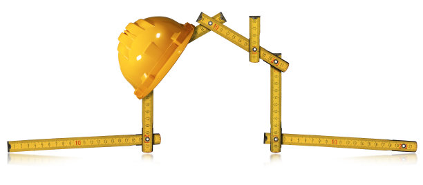 房子形状的折尺上的黄色工作头盔图片下载