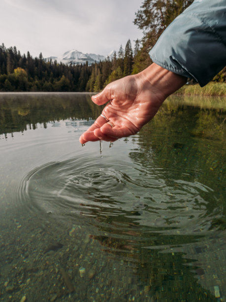 手从高山湖舀水图片下载
