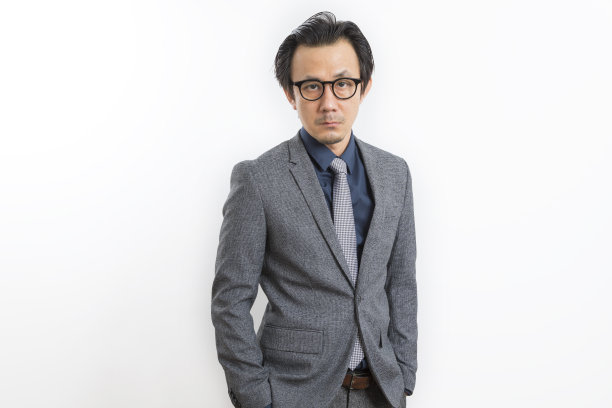 英俊的亚洲商人在灰色西装与自信和成功的姿态在白色的背景。图片下载