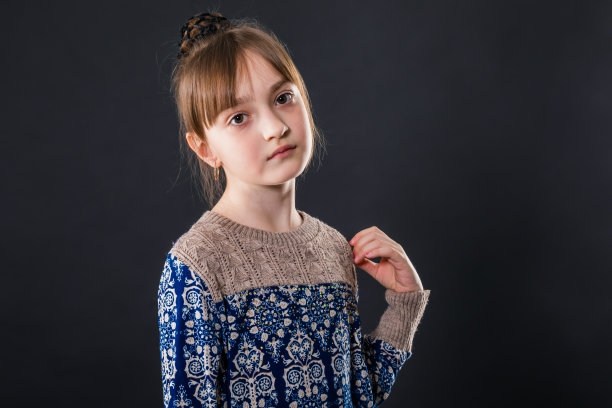 一个美丽的小女孩的肖像在黑暗的背景图片下载