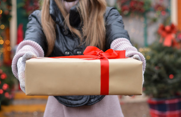 概念为圣诞节，节日，礼物，人。女孩模型赠送礼物盒的背景圣诞屋图片下载