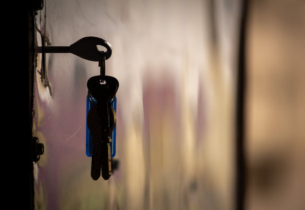 一串钥匙挂在门上。打开家里前门的钥匙。素材图片