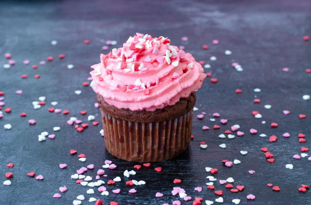 木背景上装饰有粉色奶油和心形的松饼。情人节礼物。浪漫。红色天鹅绒蛋糕。图片下载