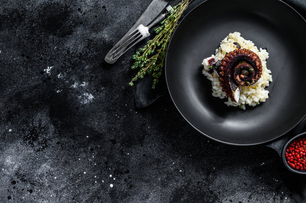 一份带章鱼触手的意大利调味饭。黑色背景。前视图。本空间图片下载