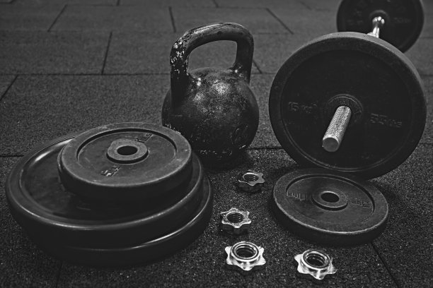 地板上放着哑铃和壶铃。健身设备。图片下载