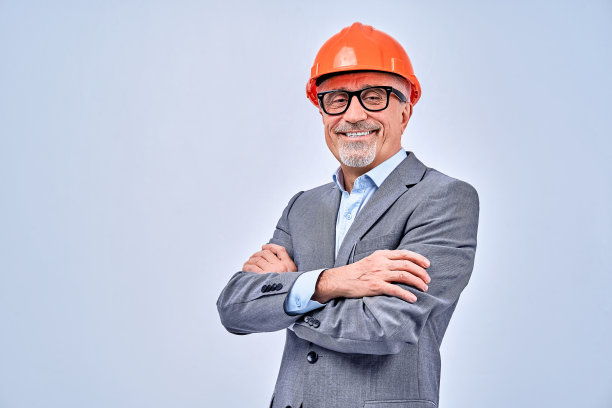 戴安全帽的快乐大胡子工头在工作室摆姿势图片下载