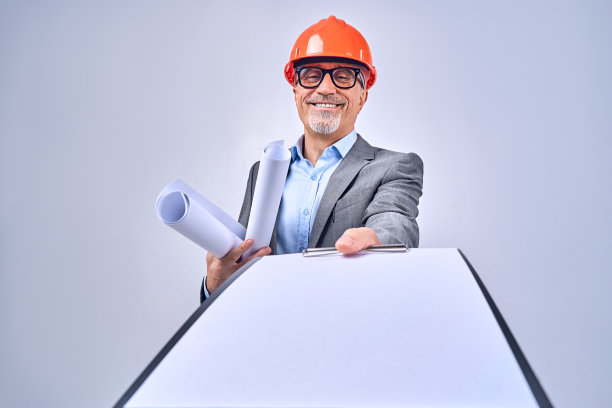 微笑的成年建筑师与设计图和合同在工作室图片下载