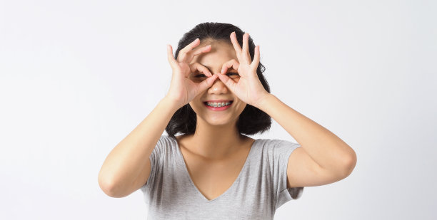 牙齿支架美丽的女孩微笑着看一个相机。白色的牙齿和蓝色的牙套。牙科保健。亚洲少女微笑与正畸配件。美容牙科，正畸治疗。白色背景工作室。图片下载