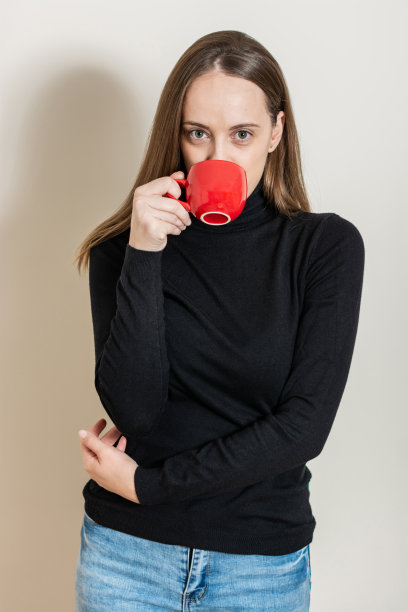 一个女人喝着咖啡看着相机的肖像图片下载