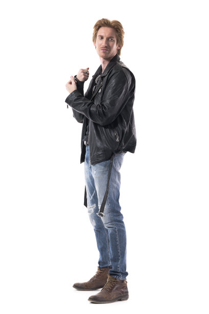 自信微笑年轻英俊的红发男人在摇滚风格的衣服，穿衣服扣袖子图片下载