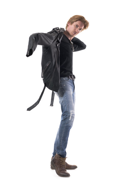 自发的照片，年轻的时尚男子穿着摇滚风格的衣服。侧视图。图片下载